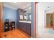 Bathroom with blue walls, hardwood floors, custom blue vanity, and marble floors in the water closet at 2499 E Maddox Rd, Buford, GA 30519