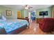 Main bedroom shows wood floors, ceiling fan, red chair, blue cabinetry in the bathroom, and TV at 2499 E Maddox Rd, Buford, GA 30519