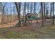 Backyard view featuring a wooden play structure with slide, swing, and climbing features at 2499 E Maddox Rd, Buford, GA 30519