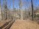 Fenced backyard with bare trees, a wire fence, and views of nearby homes at 2540 Marsha Cir, Cumming, GA 30041