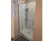 Glass-enclosed shower with built-in shelving and marble patterned shower surround at 2540 Marsha Cir, Cumming, GA 30041