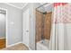 Bathroom with neutral tile, shower with patterned shower curtain, and white door at 3640 Hickory Se Cir, Smyrna, GA 30080