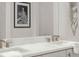 Bright bathroom features a double sink vanity, modern fixtures, and elegant decorative artwork at 201 New St # 2301, Decatur, GA 30030
