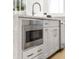 Modern kitchen boasts stainless steel oven, sleek gray cabinets, and stylish gold handles at 201 New St # 2301, Decatur, GA 30030