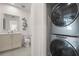 Functional laundry area with stacked washer and dryer, and a view into the bathroom at 201 New St # 2301, Decatur, GA 30030
