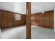 Basement features wood paneled walls, neutral gray carpet, and view from one window at 3063 Kerr Dr, Decatur, GA 30034