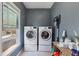 This laundry room features a side by side washer and dryer set, a window, and shelving at 976 Arthur Nw Ln, Atlanta, GA 30318