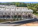 Aerial view of new construction townhomes with landscaped entrance and blacktop driveway at 201 New St # 2305-1, Decatur, GA 30030