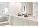 Modern bathroom featuring double sinks, marble countertops, and a glass-enclosed shower, with the primary bedroom visible at 201 New St # 2305-1, Decatur, GA 30030