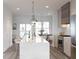Well-lit kitchen featuring stainless steel appliances, a large island with seating and pendant lights at 201 New St # 2305-1, Decatur, GA 30030