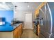 Modern kitchen featuring stainless steel appliances, wooden cabinetry, and granite countertops with a view of the living area at 845 Spring Nw St # 322, Atlanta, GA 30308