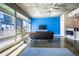 Bright living room with concrete floors, large windows, and a modern sofa facing a vibrant blue wall at 845 Spring Nw St # 322, Atlanta, GA 30308