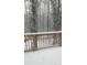 Overlooking snowy backyard with a deck and tall trees in the background offering scenic views at 3875 Wintergreen Ct, Marietta, GA 30062