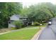 Exterior shot of home with covered porch nestled amongst mature trees, in a neighborhood setting on a rainy day at 3875 Wintergreen Ct, Marietta, GA 30062