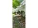 Side view of a two-story house with a long porch and a sidewalk surrounded by plants and greenery at 3875 Wintergreen Ct, Marietta, GA 30062