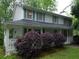 Charming two-story home with a covered porch, featuring trimmed bushes and views of the surrounding trees at 3875 Wintergreen Ct, Marietta, GA 30062
