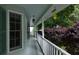 Charming front porch with white railings and green trim, offering a relaxing space with views of the garden at 3875 Wintergreen Ct, Marietta, GA 30062