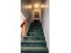 Carpeted staircase leading to the upper level, featuring wooden handrails and a decorative mirror at 3875 Wintergreen Ct, Marietta, GA 30062