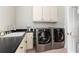 Functional laundry room with black countertop, stainless steel washer and dryer, and white cabinets at 715 Newport Holw, Alpharetta, GA 30005