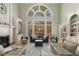 Light-filled living room with tall windows, fireplace, built-in bookshelves, and modern furnishings at 715 Newport Holw, Alpharetta, GA 30005