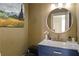 Stylish powder room with blue vanity, round mirror, designer accents, and custom wall texture at 715 Newport Holw, Alpharetta, GA 30005