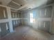 A bright bedroom features an unfinished sheetrock, view of the neighborhood through the windows, during construction at 2108 Boxwood Circle Se, Conyers, GA 30094