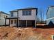 View of the exterior of a new home with light siding, dark trim, covered patio and unfinished backyard at 2108 Boxwood Circle Se, Conyers, GA 30094