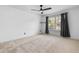 Bright bedroom with neutral carpet, ceiling fan, and a large window with curtains at 3103 Santa Fe Pkwy, Atlanta, GA 30350