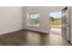 Bright empty room with dark wood floors and large window showing neighborhood view at 4075 Near Star Ln, Cumming, GA 30028