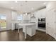 Modern white kitchen features a center island, stainless steel appliances, and abundant cabinet space at 4075 Near Star Ln, Cumming, GA 30028