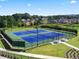 Community tennis courts with green and blue surface with neighborhood visible in distance at 4075 Near Star Ln, Cumming, GA 30028