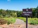 Walking trail with informational sign surrounded by abundant greenery on a sunny day at 4075 Near Star Ln, Cumming, GA 30028