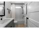 Well-lit bathroom featuring tub with subway tile surround, gray vanity, and neutral flooring at 805 Dempsey Ct, Marietta, GA 30064