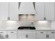 Up close, bright kitchen features white cabinetry, quartz countertops, white subway tile, and stainless steel gas cooktop at 805 Dempsey Ct, Marietta, GA 30064