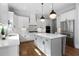 Modern kitchen boasts white cabinetry, quartz countertops, stainless steel appliances, and a gray kitchen island at 805 Dempsey Ct, Marietta, GA 30064