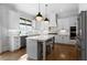 Modern kitchen with white cabinetry, hardwood floors, stainless steel appliances, a gray island, and designer pendant lighting at 805 Dempsey Ct, Marietta, GA 30064