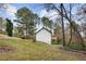 Back of house showing a deck overlooking the serene wooded backyard and sloped lawn at 247 Mandy Ct, Mcdonough, GA 30252