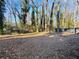 A spacious and private backyard enveloped by trees and a dark gray fence offers ample room to create outdoor living spaces at 2736 Claire Ter, Decatur, GA 30032