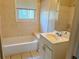 Neutral bathroom featuring a bathtub, tiled walls, and a window at 2736 Claire Ter, Decatur, GA 30032