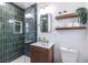 Stylish bathroom with green tiled shower, modern vanity, wood shelving, and elegant fixtures at 3020 Norton Se Ct, Smyrna, GA 30082