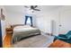 Cozy bedroom with wood floors, a ceiling fan, natural light, and a stylish teal chair at 3020 Norton Se Ct, Smyrna, GA 30082