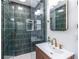 Stylish shower with modern green tiling, glass doors, gold fixtures, and a tiled niche for a luxurious experience at 3020 Norton Se Ct, Smyrna, GA 30082