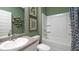 Stylish bathroom featuring a shower and tub combination and green accent walls at 509 Vervain Drive, Locust Grove, GA 30248