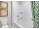 Well-lit bathroom features a white tub with shower, wall art and decorative shower curtain at 509 Vervain Drive, Locust Grove, GA 30248