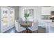 Cozy dining area features a round wooden table, elegant chandelier and a leafy plant centerpiece at 509 Vervain Drive, Locust Grove, GA 30248