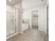 Modern bathroom features a glass-enclosed shower, soaking tub, and tiled flooring at 674 Sundial Ln, Mableton, GA 30126