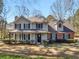 Charming two-story home with a covered front porch, shutters, and mature landscaping at 105 Lakeview Ln, Stockbridge, GA 30281