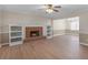 Open-concept living area with brick fireplace, built-in shelves, and ceiling fan at 105 Lakeview Ln, Stockbridge, GA 30281