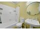 Cozy bathroom featuring white tile walls, and a pedestal sink with matching white toilet at 231 Peachtree Ne Way, Atlanta, GA 30305