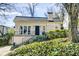 Charming brick home featuring an arched front door, landscaped yard, and classic architectural details at 231 Peachtree Ne Way, Atlanta, GA 30305